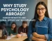 Confident international psychology student holding a notebook in a diverse classroom setting while studying abroad